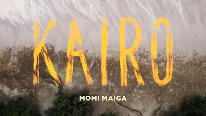 Still aus dem Videovorspann mit dem Titel "Kairo" in großen gelben Buchstaben auf einem pittoresk wirkenden Hintergrund, der wie eine Collage aus Luftaufnahmen der Erde und einer reflektierenen, leicht welligen Wasseroberfläche wirkt.