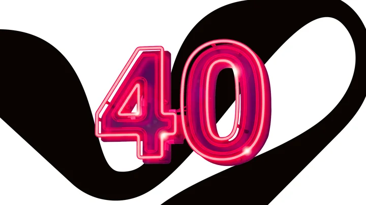 Ein rotes Neonzeichen zeigt die Zahl 40 vor einem geschwungenen, schwarzen Hintergrundmuster. Es stellt ein Jubiläum dar.