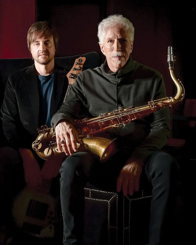 Vier Männer sitzen mit Musikinstrumenten in einem dunklen Raum. Eine entspannte Atmosphäre, die auf eine Jazz-Band hindeutet.