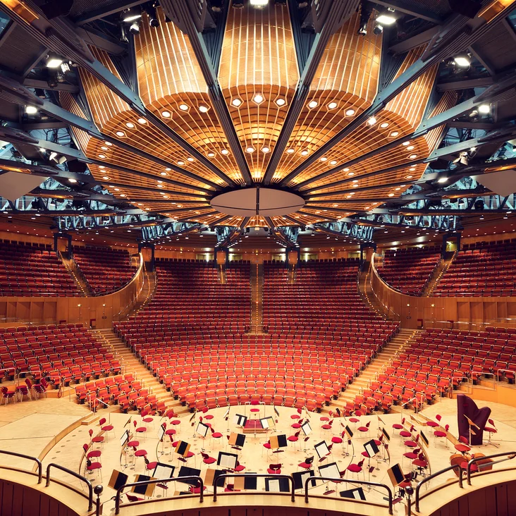 The Kölner Philharmonie: A stunning concert hall with modern architectural details, red seating, and a large stage set for orchestral performances.