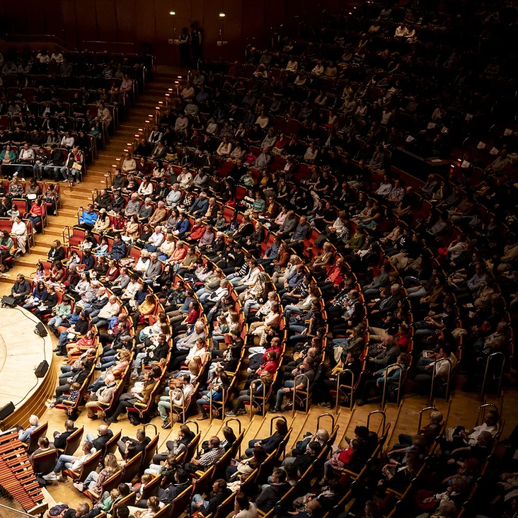Kölner Philharmonie: A packed concert hall with a large audience seated in a semi-circular auditorium, ready for an event.