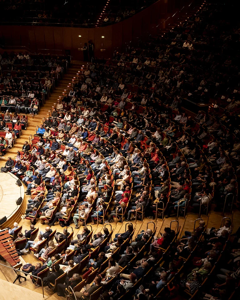 Kölner Philharmonie: A packed concert hall with a large audience seated in a semi-circular auditorium, ready for an event.