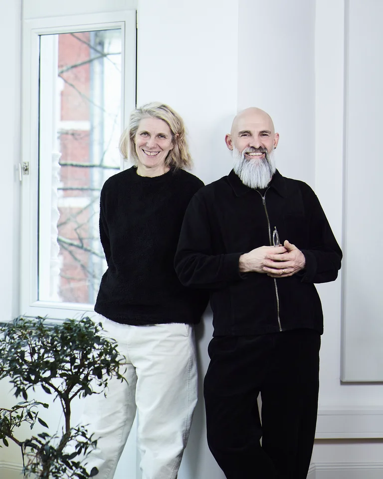 Die beiden Geschäftsführer von MIR MEDIA - Digital Agentur Eva-Maria Schreiner und Oliver Priester lehnen an einer Wand.