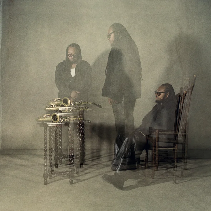 Verschwommene Aufnahme von einem Mann (Immanuel Wilkins) mit Saxophonen, in einem kunstvollen, geheimnisvollen Setting. Eine faszinierende Darstellung von Jazzästhetik.