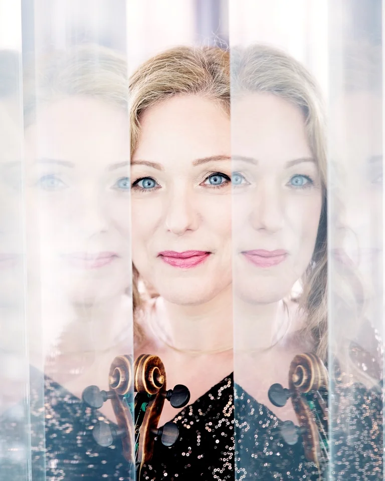 Ein künstlerisches Porträt einer Frau (Nikolaj Lund), das mehrfach gespiegelt erscheint. Sie trägt ein schwarzes Kleid, Hintergrund unscharf.