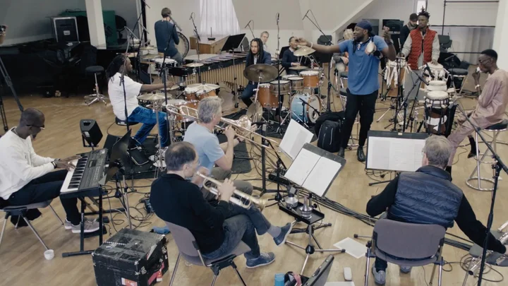 Members of the Deggo Band and Ensemble Modern are rehearsing in a studio.