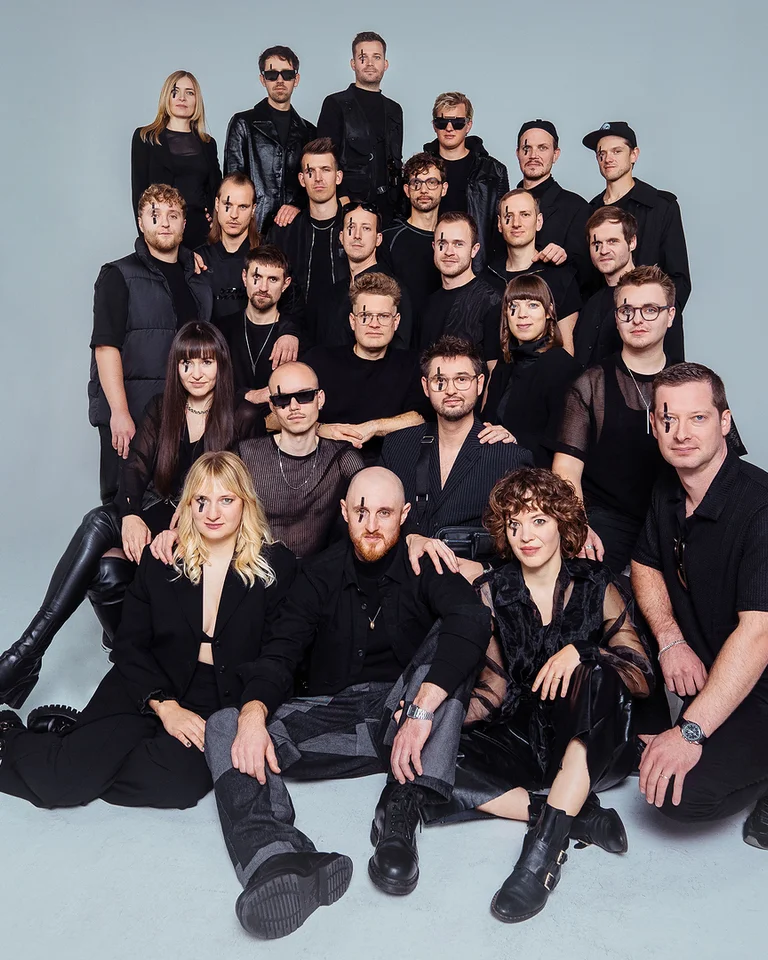 Eine große Gruppe von Menschen in schwarzer Kleidung (Jazzrausch Bigband) posiert in mehreren Reihen vor einem neutralen Hintergrund.