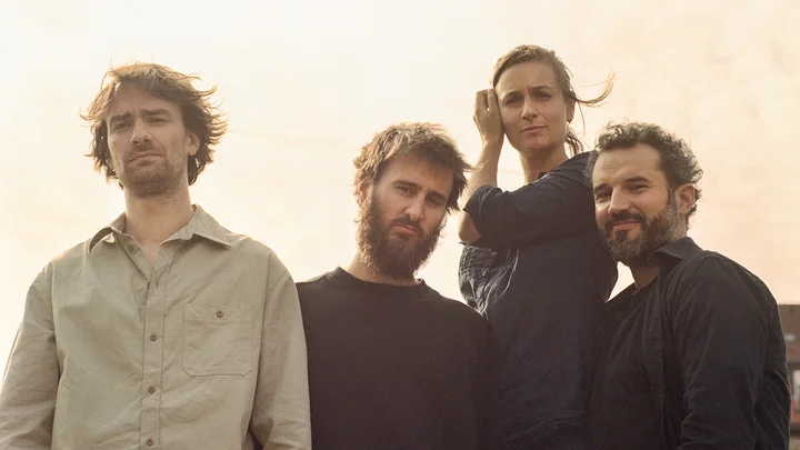 Nevermind Quartett: Vier Personen stehen für ein Foto draußen in der Sonne. Sie tragen Freizeitkleidung und schauen in die Kamera.