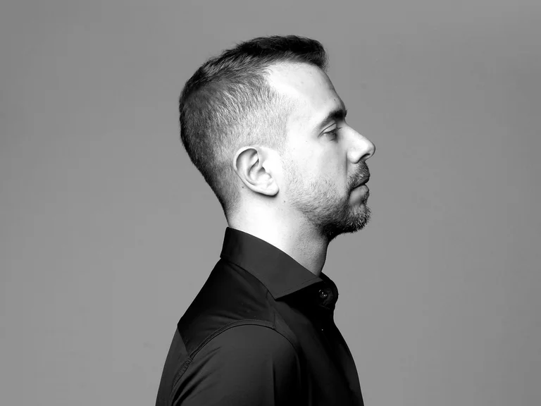 Schwarz-Weiß-Profilbild eines Mannes (Leonardo Casalini) mit kurzem Haar, der nach rechts schaut. Er trägt ein dunkles Hemd vor grauem Hintergrund.